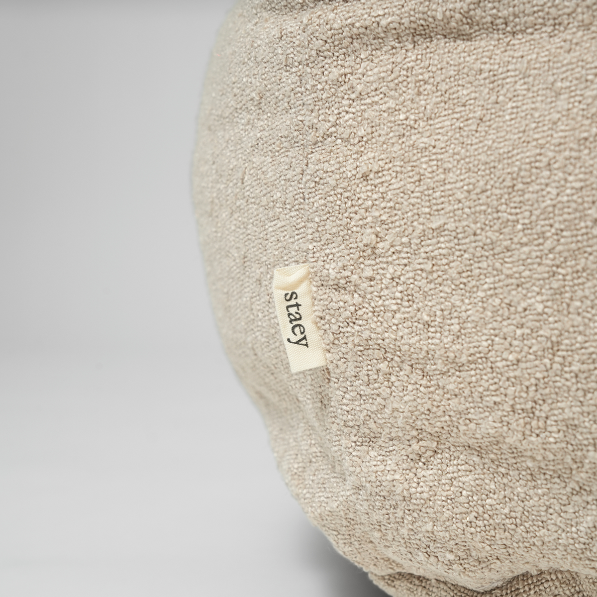 Närbild på Staey-etiketten på hundkorgen Luna i oat bouclé