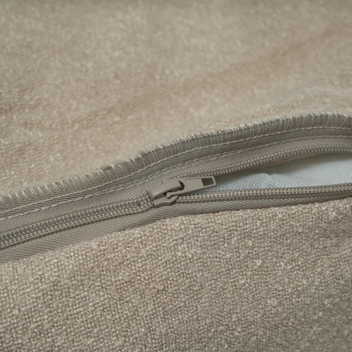 Närbild på dragkedjan på det avtagbara överdraget till sängen ”Luna” i oat bouclé