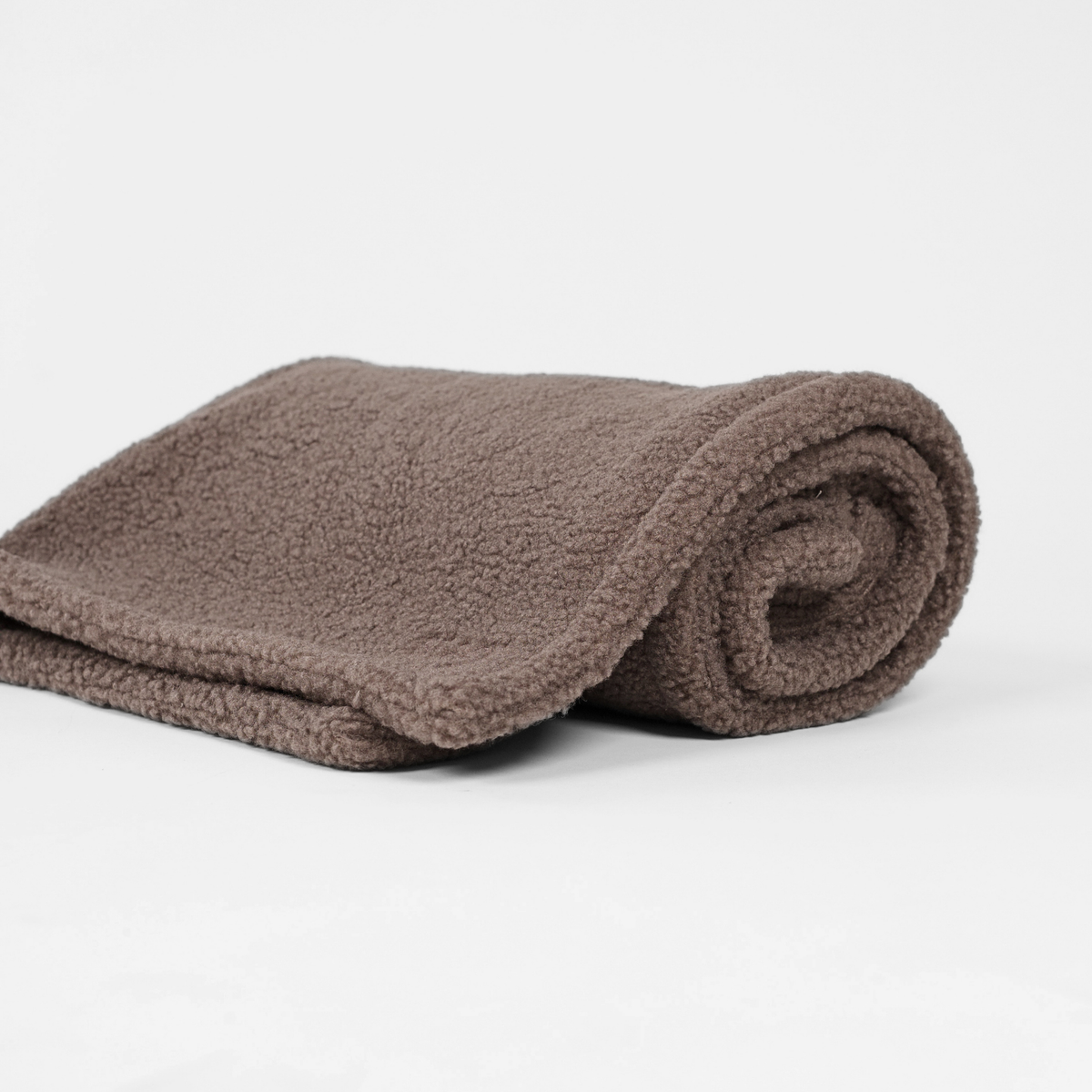 Den taupefärgade teddyhundfilten, ihoprullad