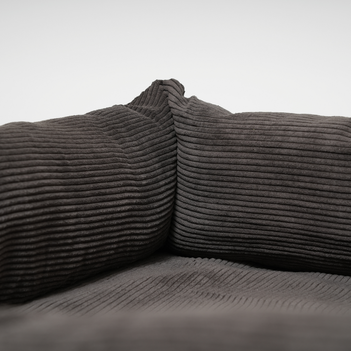 Närbild på corduroy-kudden inuti den charcoal-färgade hundkorgen